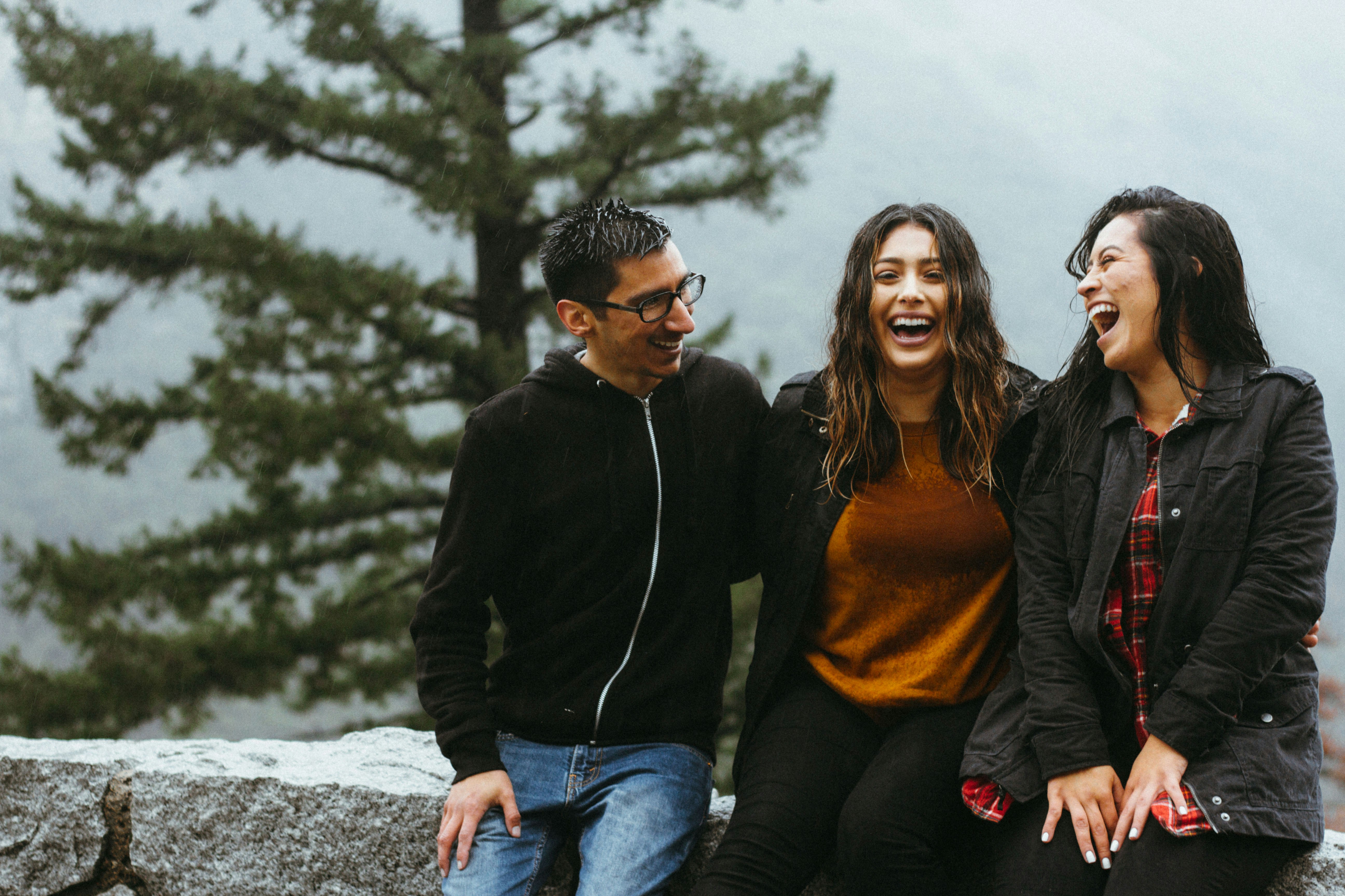 Three friends laughing together outdoors